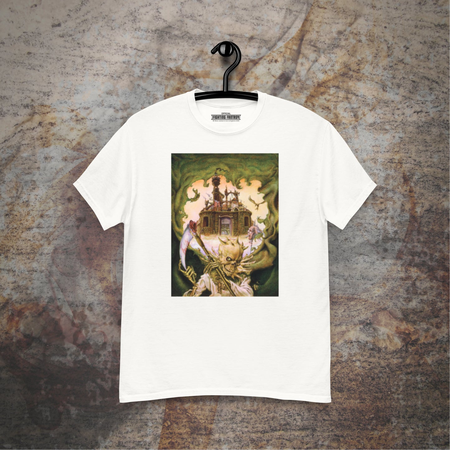 City of Thieves design on a white t-shirt hanging in front of a stone wall background.