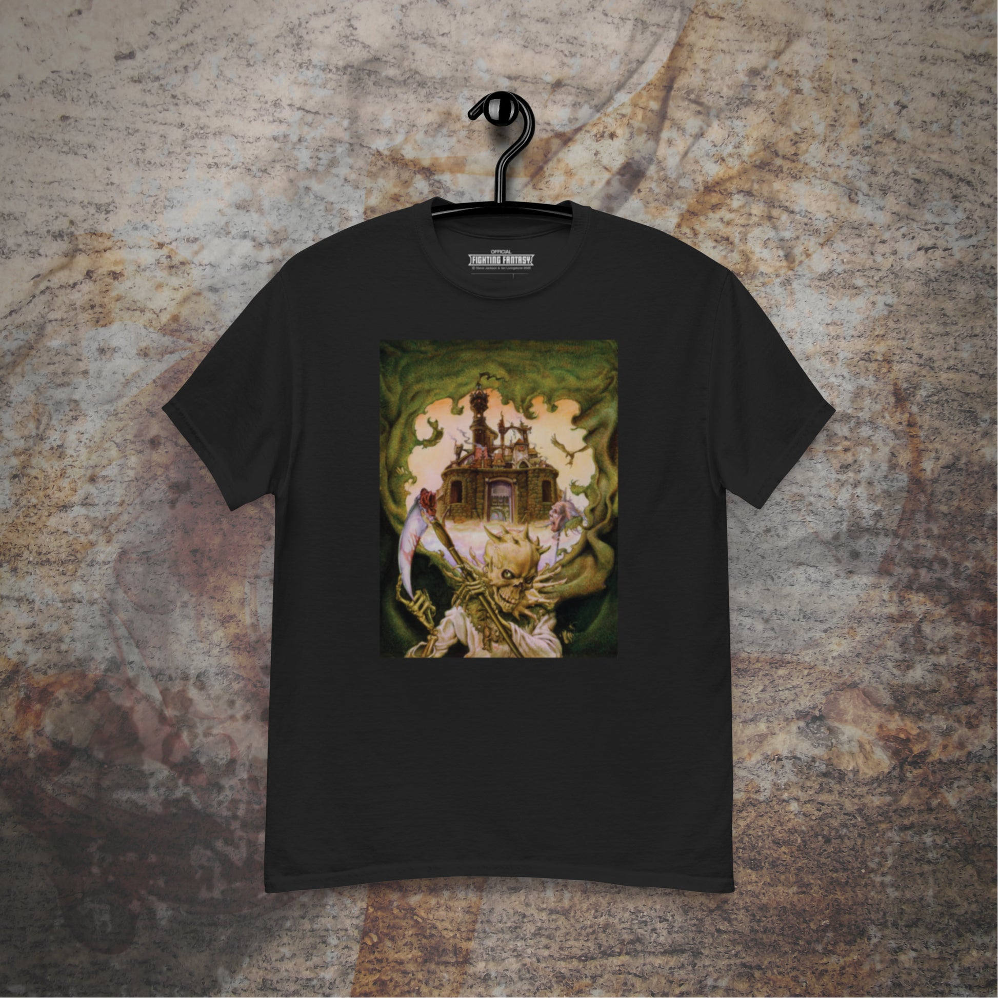 City of Thieves design on a black t-shirt hanging in front of a stone wall background.