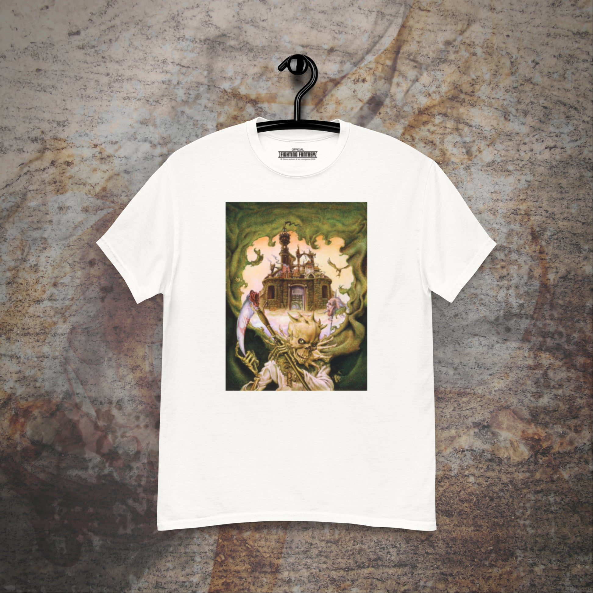 City of Thieves design on a white t-shirt hanging in front of a stone wall background.