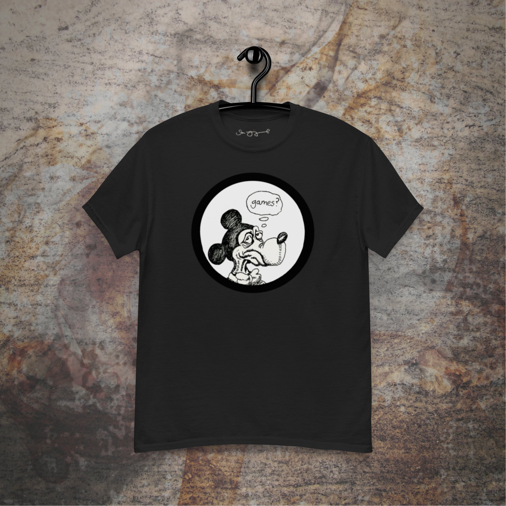 Games design on a black t-shirt hanging in front of a stone wall background.