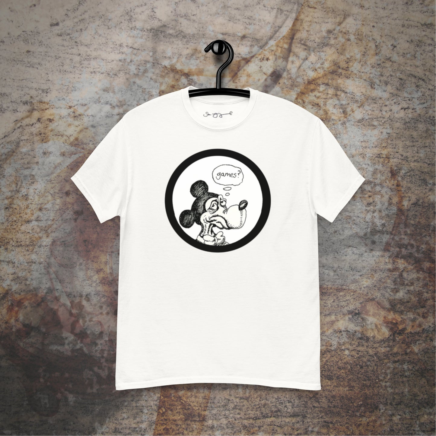 Games design on a white t-shirt hanging in front of a stone wall background.