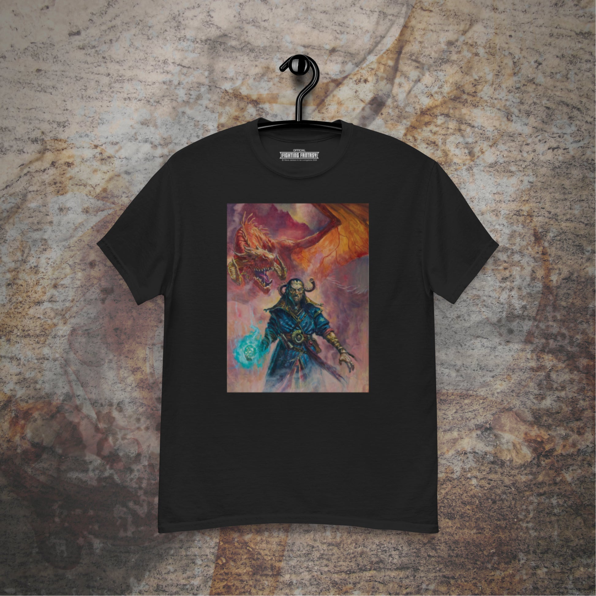 Warlock of Firetop Mountain design on a black t-shirt hanging in front of a stone wall background.