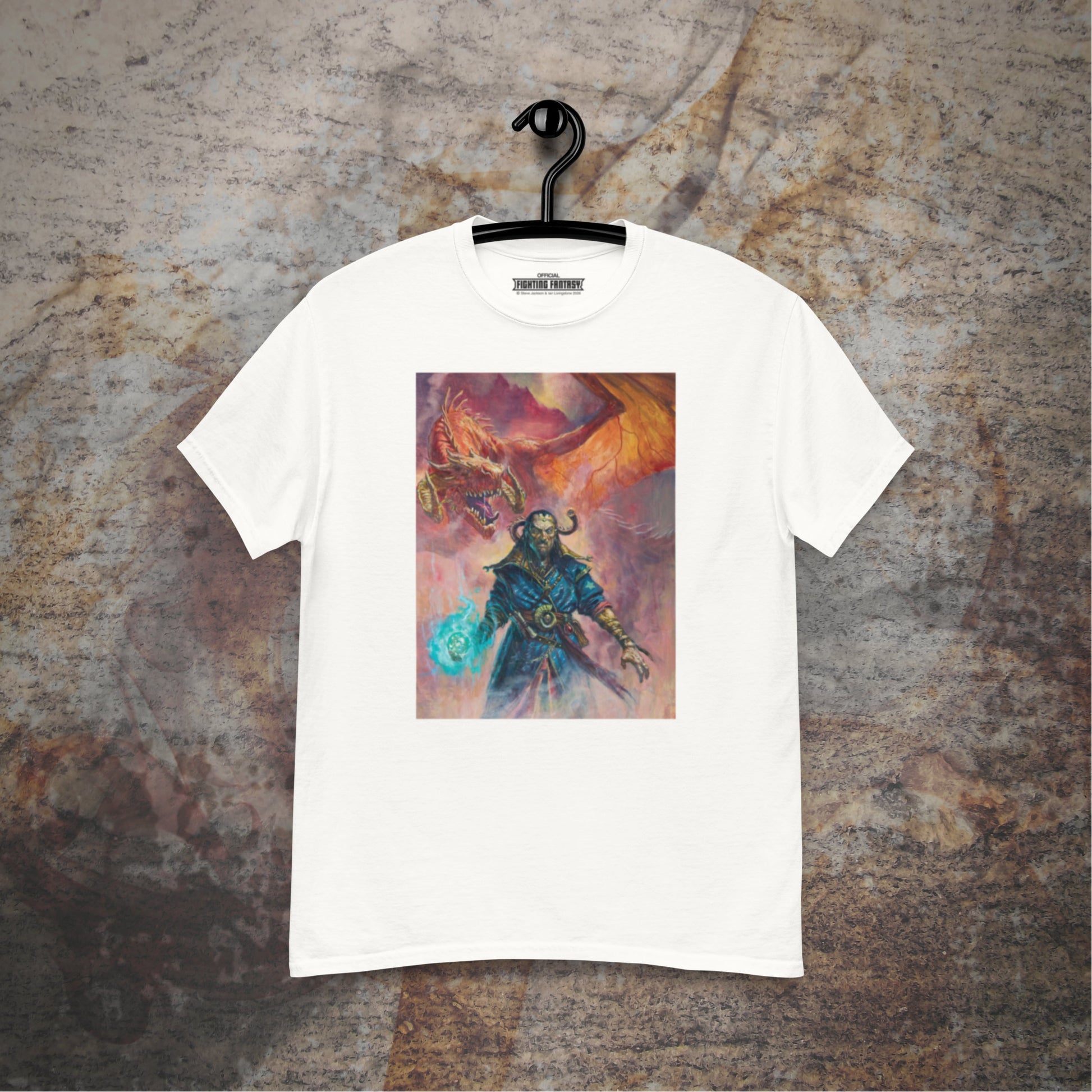 Warlock of Firetop Mountain design on a white t-shirt hanging in front of a stone wall background.
